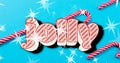 Image of jolly text over star sand candy canes on blue background at christmas