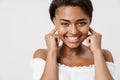 Image of joyful african american woman laughing and plugging her ears