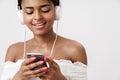 Image of joyful african american woman using cellphone and headphones