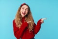 Image of joyful caucasian woman laughing and pointing fingers aside