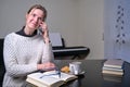 Image of joyful nice woman in eyeglasses talking on cellphone while reading book