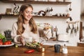 Image of joyful nice woman laughing while cooking dinner