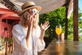 Image of joyful nice woman talking on cellphone while drinking cocktail Royalty Free Stock Photo