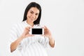 Image of joyful pregnant woman 30s with big belly smiling and holding smartphone in hand Royalty Free Stock Photo