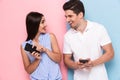 Image of joyous couple using smartphones together, isolated over
