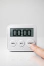 Digital kitchen timer at zero with finger pressing start Royalty Free Stock Photo