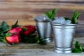 Image for Kentucky Derby in May showing two silver mint julep cups with crushed ice and fresh mint in a rustic setting