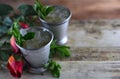 Image for Kentucky Derby in May showing two silver mint julep cups with crushed ice and fresh mint in a rustic setting.