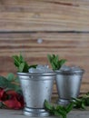 Image for Kentucky Derby in May showing two silver mint julep cups with crushed ice and fresh mint in a rustic setting. Royalty Free Stock Photo