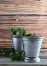 Image for Kentucky Derby in May showing two silver mint julep cups with crushed ice and fresh mint in a rustic setting. Royalty Free Stock Photo