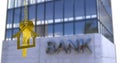 Image of key in house keychain over bank text on modern building