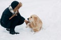 Image of labrador giving paw to girl in winter park