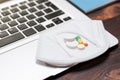 Image of a laptop and a protective medical mask with pills. Concept of online consultation with a doctor. Self-medication,