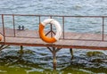 Life buoy hanging on the pier bridge near the water Royalty Free Stock Photo