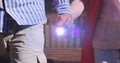 Image of light moving over midsection of senior couple walking in park holding hands