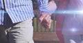 Image of light moving over midsection of senior couple walking in park holding hands