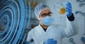 Image of loading circles, computer language, caucasian scientist wearing mask examining liquid Royalty Free Stock Photo