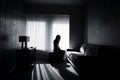 The image of a lonely individual sitting in their home, consumed by the negative emotions of their mental health crisis.