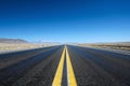 An image of a long, vacant road with yellow lines in the center, leading towards the distant horizon, An open highway under the Royalty Free Stock Photo