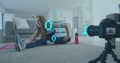 Image of looping binary codes, caucasian woman recordings stretching exercise on image recorder
