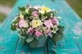 Image of lovely flowers arrangement with white eustoma, spray roses, carnations in the mint cup on the wooden table