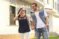 Image of lovely happy couple in summer clothes smiling and holding hands together while walking through city street Royalty Free Stock Photo