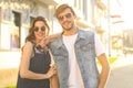 Image of lovely happy couple in summer clothes smiling and holding hands together while walking through city street Royalty Free Stock Photo