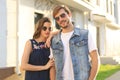 Image of lovely happy couple in summer clothes smiling and holding hands together while walking through city street Royalty Free Stock Photo