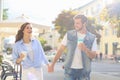 Image of lovely happy couple in summer clothes smiling and holding hands together while walking through city street Royalty Free Stock Photo