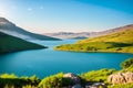 lush spring vegetation on the lake, grass, rocks, blue water, mountains, haze, cloudy sky, evening. Israel, Royalty Free Stock Photo