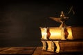 Image of magical aladdin lamp and old books. Lamp of wishes. Royalty Free Stock Photo