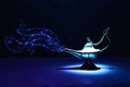 Image of magical mysterious aladdin lamp with glitter smoke. Dark background and dramatic light