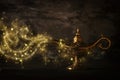 Image of magical mysterious aladdin lamp with glitter sparkle smoke over black background. Lamp of wishes. Royalty Free Stock Photo