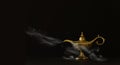 Image of magical mysterious aladdin lamp with glitter sparkle smoke over black background. Lamp of wishes Royalty Free Stock Photo