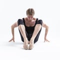 Image of Male Ballerino Dancer Sitting While Practising Stretching Exercices In Black Sportive Tights in Studio