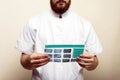 Image of male doctor or dentist holding and looking at old dental x-ray, analyzing