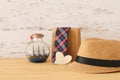 Image of male fedora hat and boat in the bottle over wooden tabl Royalty Free Stock Photo