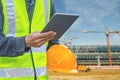 Image with male hand hold and touch screen with sending text on smart phone, tablet,cellphone over blurred Construction site backg Royalty Free Stock Photo