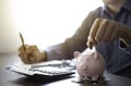 image of man hand putting coins in pink piggy bank for account save money. Royalty Free Stock Photo