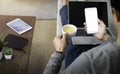 Image of man hand using, holding smartphone or mobile mockup with blank white screen display and laptop computer. Royalty Free Stock Photo