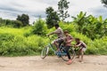 Image of man with kids riding bike in Khmer countryside. Royalty Free Stock Photo