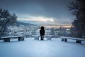 Winter Scene with A Lone Man Sitting on Snowy Benches Overlooking Bergen City Center in A Storm