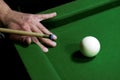 Image of a man playing snooker. Hand, cue, green table and a white ball. Royalty Free Stock Photo