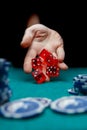 Image of man throwing red dices on table with chips in casino Royalty Free Stock Photo