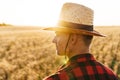 Image of masculine adult man looking aside while standing at cereal field