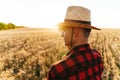 Image of masculine adult man looking aside while standing at cereal field