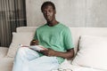 Image of african american man studying with exercise book at home