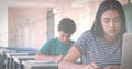 Image of mathematical equations over schoolgirl using laptop in classroom Royalty Free Stock Photo