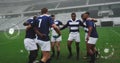 Image of media icons over diverse male rugby team in huddle at stadium