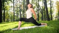 Photo of middle aged smiling woman practising yoga asana. Persong meditating in nature. Balance and harmony of body and